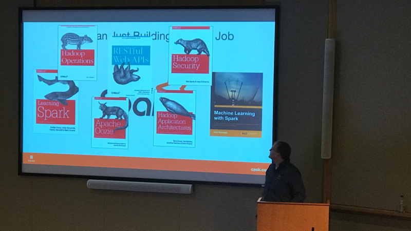 Presenter showing big data and Spark technology books